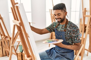 Sticker - Young african american artist man smiling happy painting at art studio.