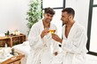 © Krakenimages.com - Two hispanic men couple toasting with champagne sitting on massage table at beauty center