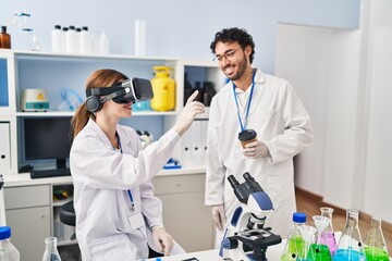 Sticker - Man and woman scientist partners using vr goggles and drinking coffee at laboratory