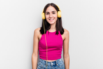 Young caucasian woman listening to music isolated on white background happy, smiling and cheerful.