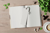 Fototapeta  - Open book with a bookmark on the table mockup. 3D rendering