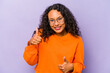 © Asier - Young hispanic woman isolated on purple background raising both thumbs up, smiling and confident.