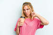 © Asier - Young caucasian woman holding a take away coffee isolated on blue background showing a dislike gesture, thumbs down. Disagreement concept.