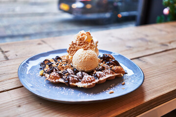 Wall Mural -  Plate of waffle with chocolate sauce and ice cream on wooden surface