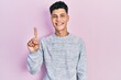 © Krakenimages.com - Young hispanic man wearing casual clothes showing and pointing up with finger number one while smiling confident and happy.