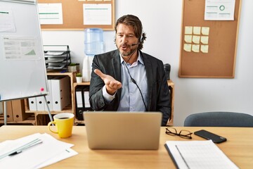 Poster - Handsome middle age man wearing call center agent headset at the office looking at the camera blowing a kiss with hand on air being lovely and sexy. love expression.