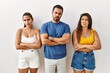 Group of young hispanic people standing over isolated background skeptic and nervous, disapproving expression on face with crossed arms. negative person.