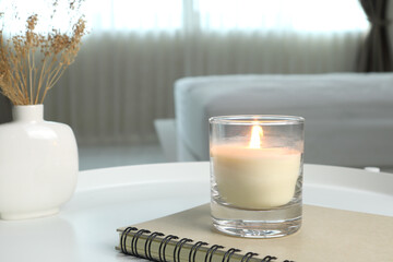 Wall Mural - luxury lighting aromatic scented candle is on white metal table with ceramic vase and notebook to creat warm and relax ambient in the bedroom with background of white bed and curtain on Valentine day