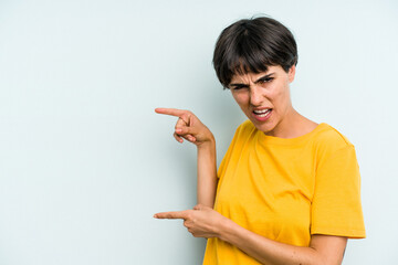 Young caucasian woman with a short hair cut isolated pointing with forefingers to a copy space, expressing excitement and desire.