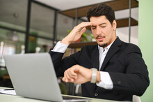 Upset Latin Male Office Employee Looking At The Watch And Checking Time, Missed Important Meeting, Has Deadline With Project, Forgot About Appointment
