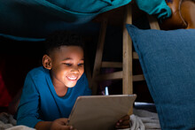 Image Of African American Boy Using Laptop Under Blanket