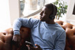 © Wavebreak Media - Image of relaxed african american in headphones sitting on sofa