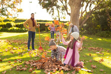 Image Of Happy Multi Generation Caucasian Family Having Fun With Leaves In Autumn Garden