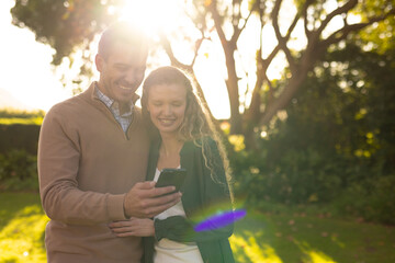 Wall Mural - Image of happy caucasian couple taking selfie in garden