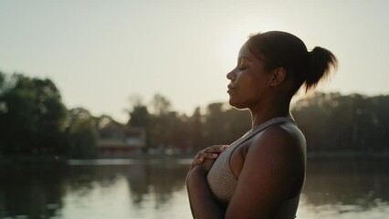 Wall Mural - African American woman practicing breathing exercise at the park. Shot with RED helium camera in 8K.    