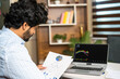 © WESTOCK - young man busy analysing Companies financial charts with technical stock mart charts on laptop - concept of investment, trading and money management