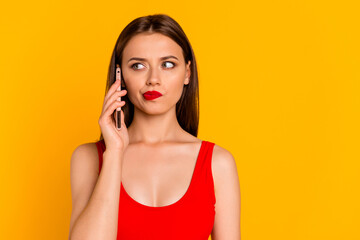 Wall Mural - Photo of pretty girl speak communicate telephone hesitate think isolated on yellow color background