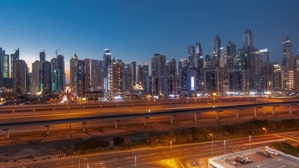 Wall Mural - Panorama of Dubai marina tallest block of skyscrapers day to night transition timelapse. Aerial view from JLT district to apartment buildings, hotels and office towers near highway.