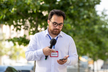 journalist brunette young professional journalist reporting news on television looking at phone