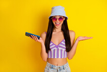 Photo Of Shiny Impressed Girl Dressed Swimsuit Bra Cap Dark Eyewear Chatting Modern Gadget Isolated Yellow Color Background