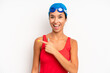 © kues1 - hispanic pretty woman looking excited and surprised pointing to the side. swimmer concept
