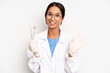 © kues1 - hispanic pretty woman smiling happily, waving hand, welcoming and greeting you. dentist student concept