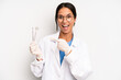 © kues1 - hispanic pretty woman looking excited and surprised pointing to the side. dentist student concept