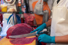 Crop Man Cutting Meat In Butchery