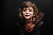 © ADDICTIVE STOCK - Sad little child in Halloween costume crying in dark studio