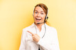 pretty blonde young woman looking excited and surprised pointing to the side. telemarketer concept