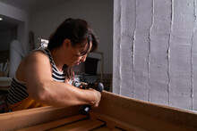 Focused Female Master Using Drill During Work In Studio