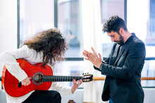 Man Applauding To Artist Playing Guitar In Studio