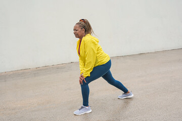 Fit african senior woman doing sport stretching workout outdoor