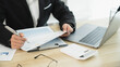 © mojo_cp - Financial inspector calculating a numbers in office room.