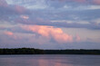 Purple sunset over water witha variety of cloud types including cumulus, cumulounimus, altostratus