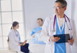 © lenets_tan - Doctor holding folder in front of a patient and a doctor