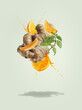 © VICUSCHKA - Flying ginger with orange slices and juice splashing at pale green background mint leaves. Ingredients for refreshing summer drinks. Creative levitation food and drink concept. Front view.