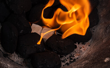 Lighting a barbecue fire. Briquette and white cube grill lighter. Flame with charcoal.