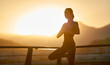 © vitaliymateha - Portrait healthy beautiful woman standing in yoga pose on bridge with golden sunlight background. Morning practicing meditation