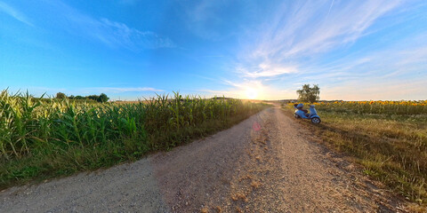 Wall Mural - Bavarian Summer landscape with a path and a motor roller in parking condition