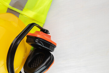 Wall Mural - safety work protective accessories, worker's uniform, engineer's helmet, earmuffs, reflective vest on a white background, copy space