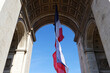 The French flag under the Triumphal arch. The tomb of the unknown soldier. Paris. France.