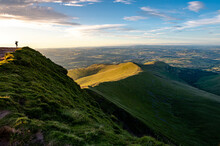 View Of A Man Taking Photos Ontop Of A Mountain Taking In The News At Pen Y Fan Brecon Beacons South Wales Uk