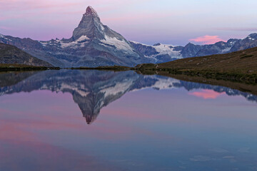 Wall Mural - Early lights of dawn on Matterhorn summit reflecting on a mountain lake.