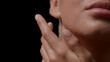© pavel_dp - Macro shot of good-looking young slim white-skinned woman with water drops on her face and hand is going to touch her neck on black background | Skin hydration concept