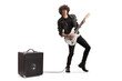 © Ljupco Smokovski - Full length portrait of a young musician playing a guitar plugged into an amplifier
