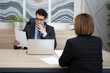 © Vitaliy - Young serious business man looking at resume of young female employee on interview in the office. Internship and human resource concept