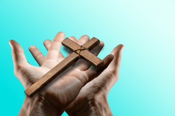 Wall Mural - Human hand holding wooden cross crucifix. Catholicism, Christianity, Thanksgiving, Catholic and Christian faith concept.