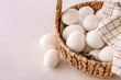 © Pixel-Shot - Wicker basket with white chicken eggs on light background, closeup