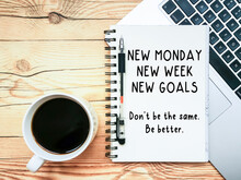 Open Notebook With Text "New Monday. New Week. New Goals" And A Laptop On Wooden Background.